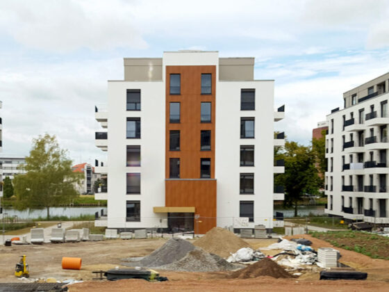Bauplatz mit neuen Wohngebäuden und Baustellenmaterialien in urbaner Umgebung.