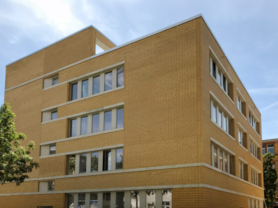 Kopernikus-Oberschule in Berlin mit moderner Architektur: Neubau mit hellen Ziegeln und großen Fenstern in städtischer Umgebung.