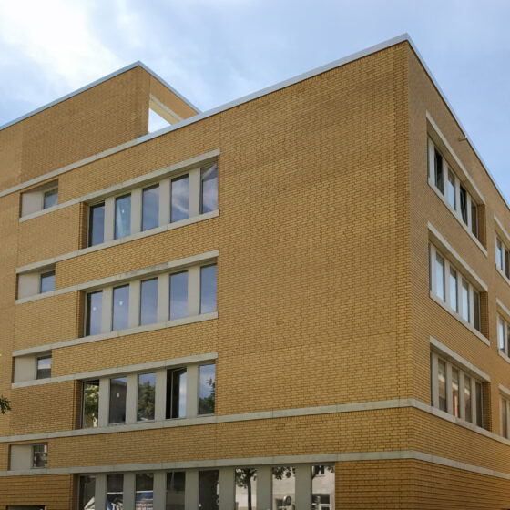 Kopernikus-Oberschule in Berlin mit moderner Architektur: Neubau mit hellen Ziegeln und großen Fenstern in städtischer Umgebung.