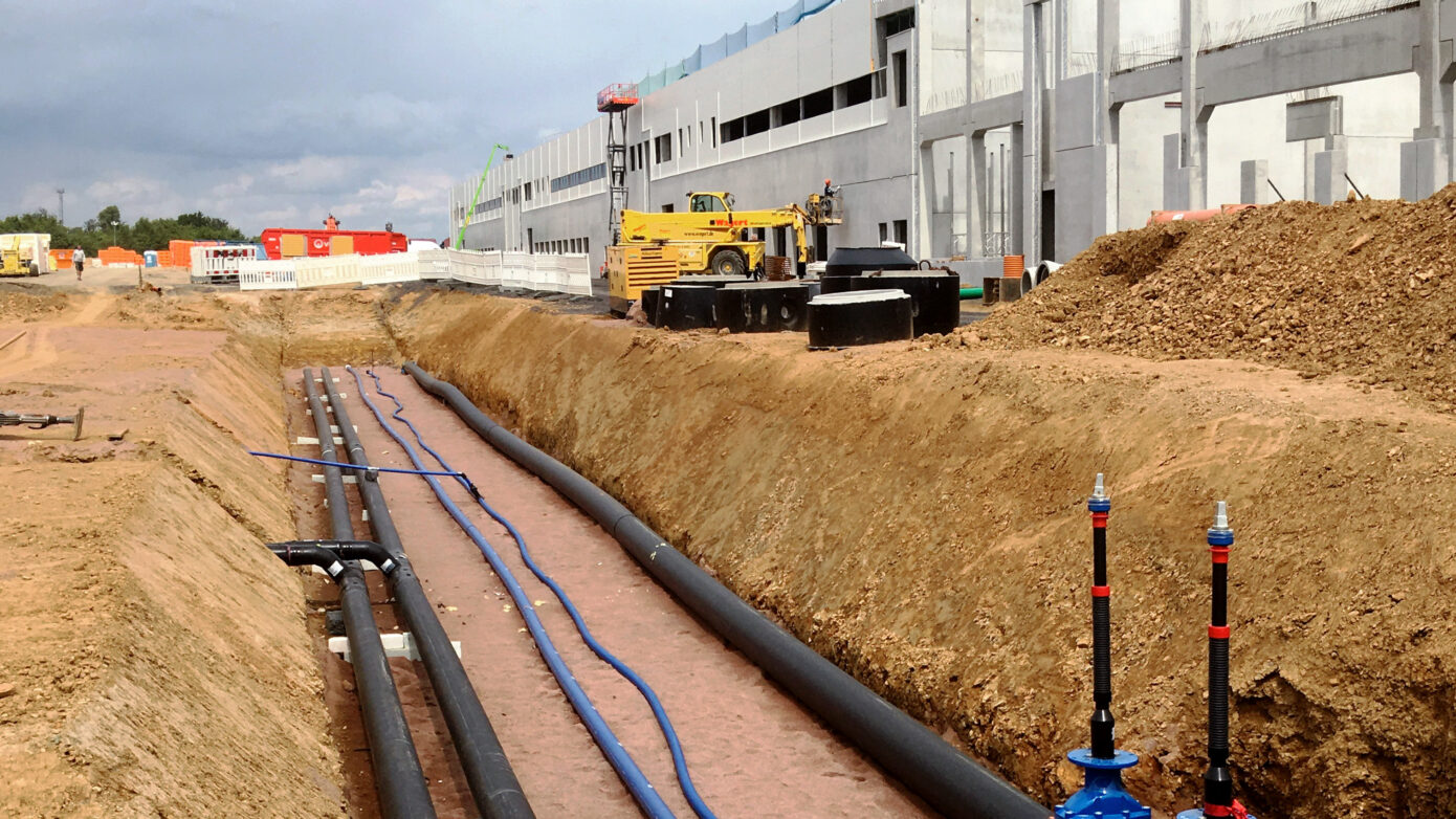 Bauarbeiten für die Logistikhalle in Hainichen mit Rohrleitungen und Maschinen auf einer Baustelle für ein neues Gebäude.