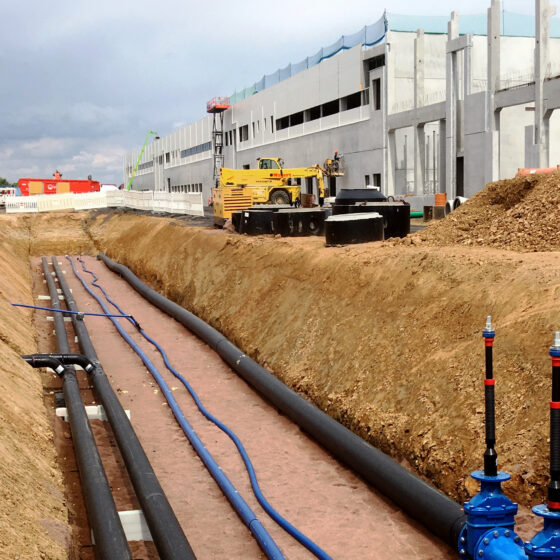 Bauarbeiten für die Logistikhalle in Hainichen mit Rohrleitungen und Maschinen auf einer Baustelle für ein neues Gebäude.