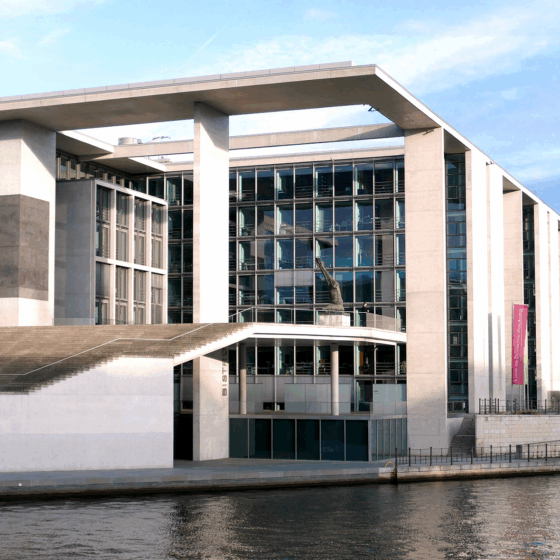 Erweiterungsbau am Wasser in Berlin mit Fernsehturm im Hintergrund.