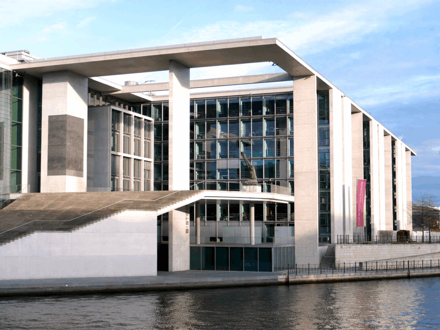 Erweiterungsbau am Wasser in Berlin mit Fernsehturm im Hintergrund.