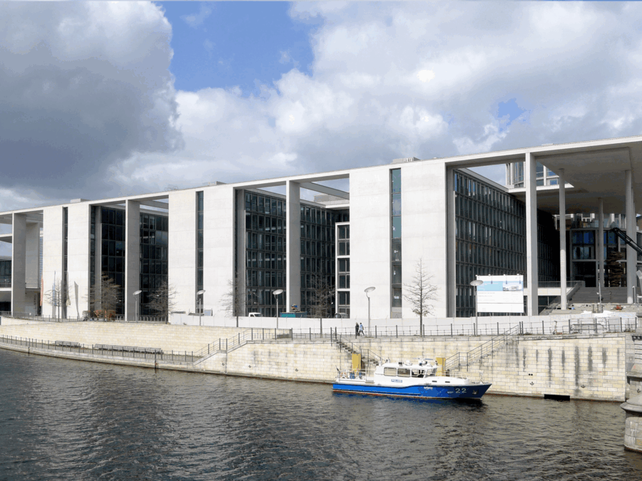 Erweiterungsbau in Berlin am Wasser, umgeben von Wolken und Stadtarchitektur.