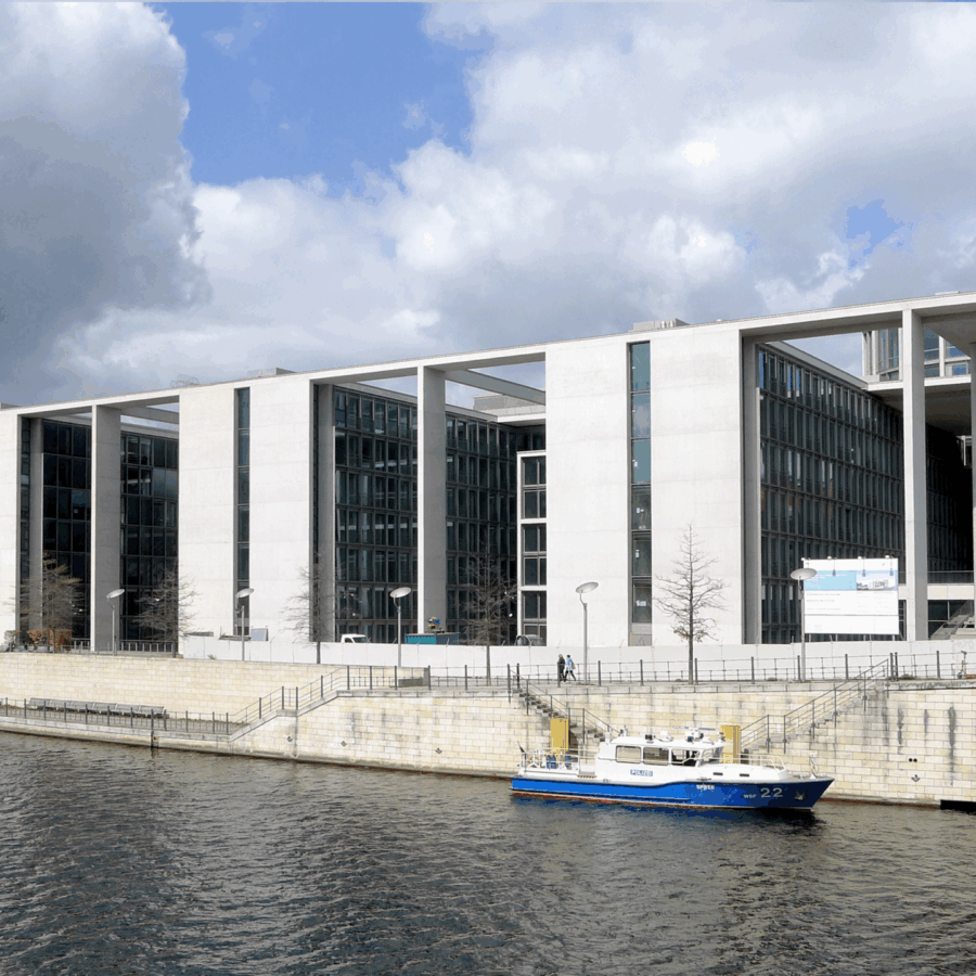 Erweiterungsbau in Berlin am Wasser, umgeben von Wolken und Stadtarchitektur.