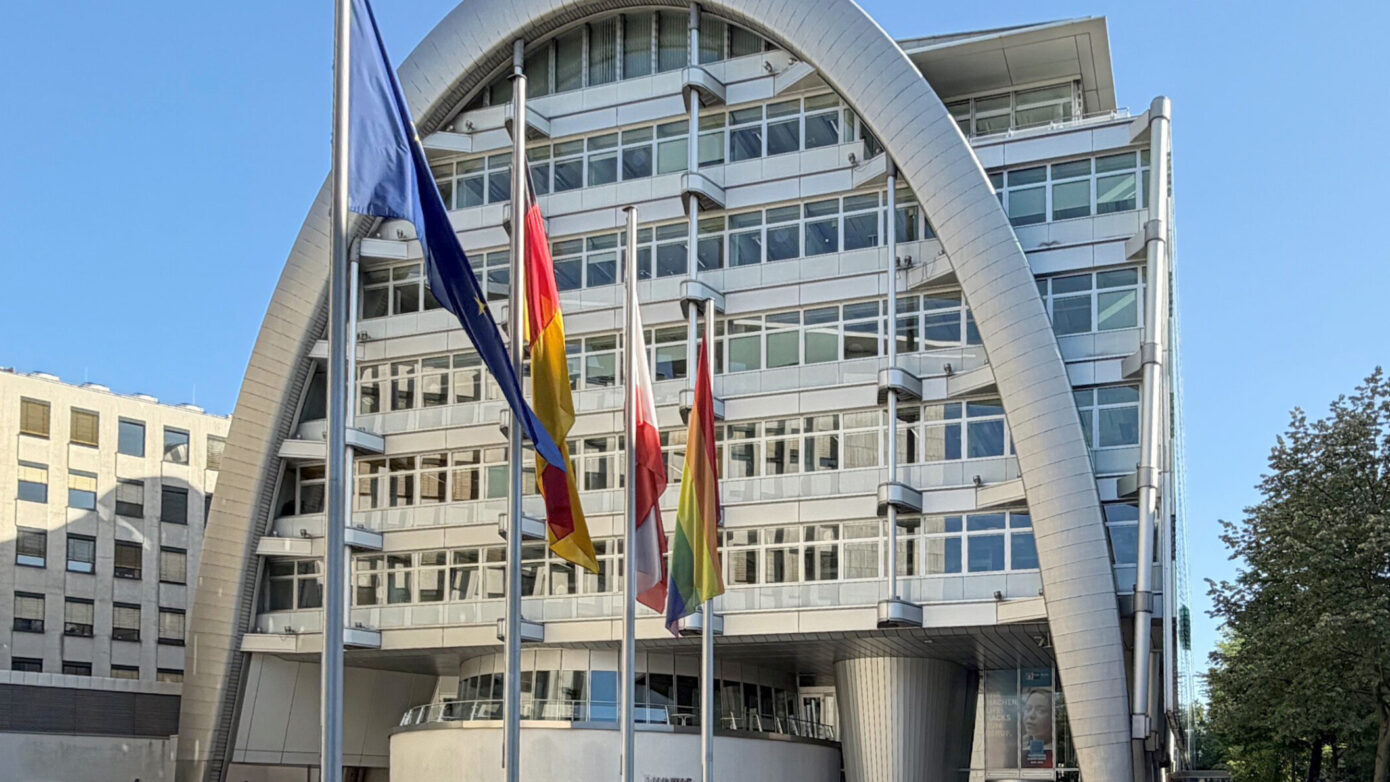 Ludwig Erhard Haus (IHK) mit moderner Architektur mit Flaggen vor blauen Himmel.