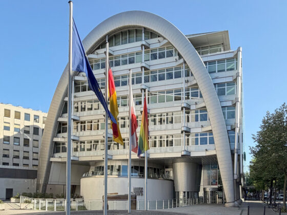 Ludwig Erhard Haus (IHK) mit moderner Architektur mit Flaggen vor blauen Himmel.