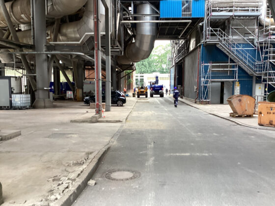 Müllheizkraftwerk (MHKW) Ruhleben mit Arbeitern und Fahrzeugen in einer modernen Produktionsumgebung.