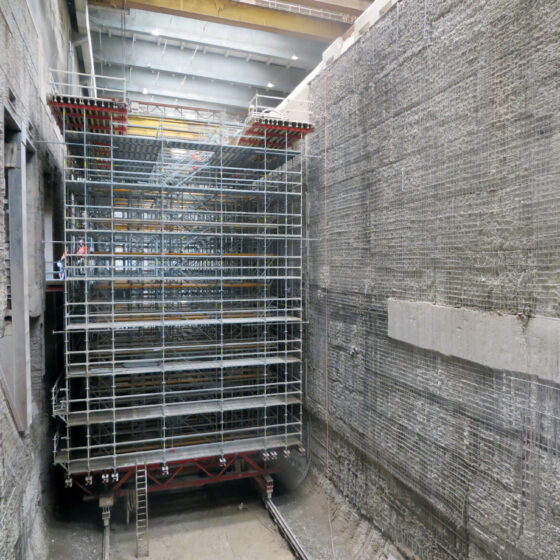 Blick in einen leeren Müllbunker mit Baugerüst.