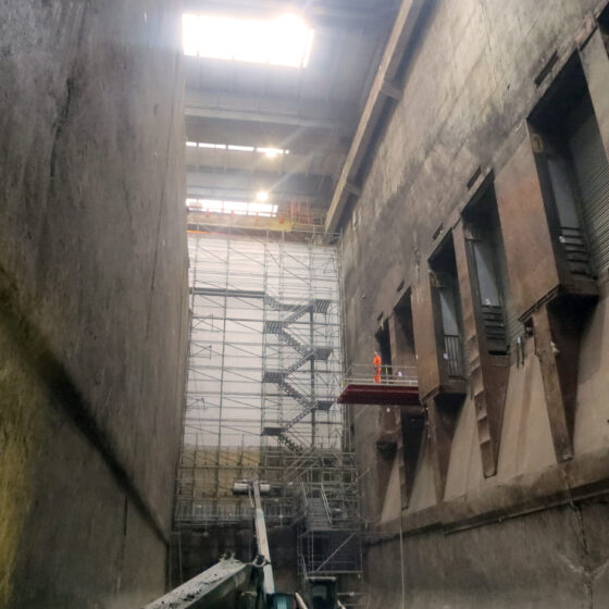 Blick in einen Müllbunker mit Gerüst und natürlichem Licht.