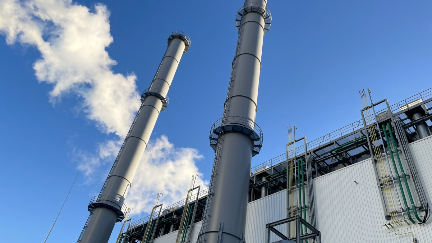 Blockheizkraftwerk Bremen Hastedt mit hohen Schornsteinen und blauem Himmel.