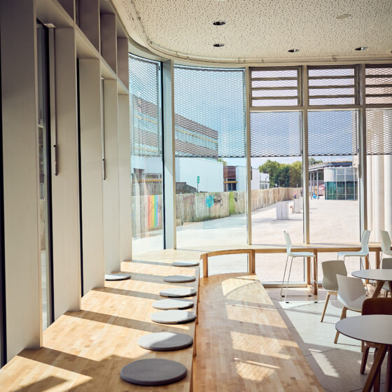 Helle, moderne Innenarchitektur mit Holzbar und großen Fenstern in einem Café.