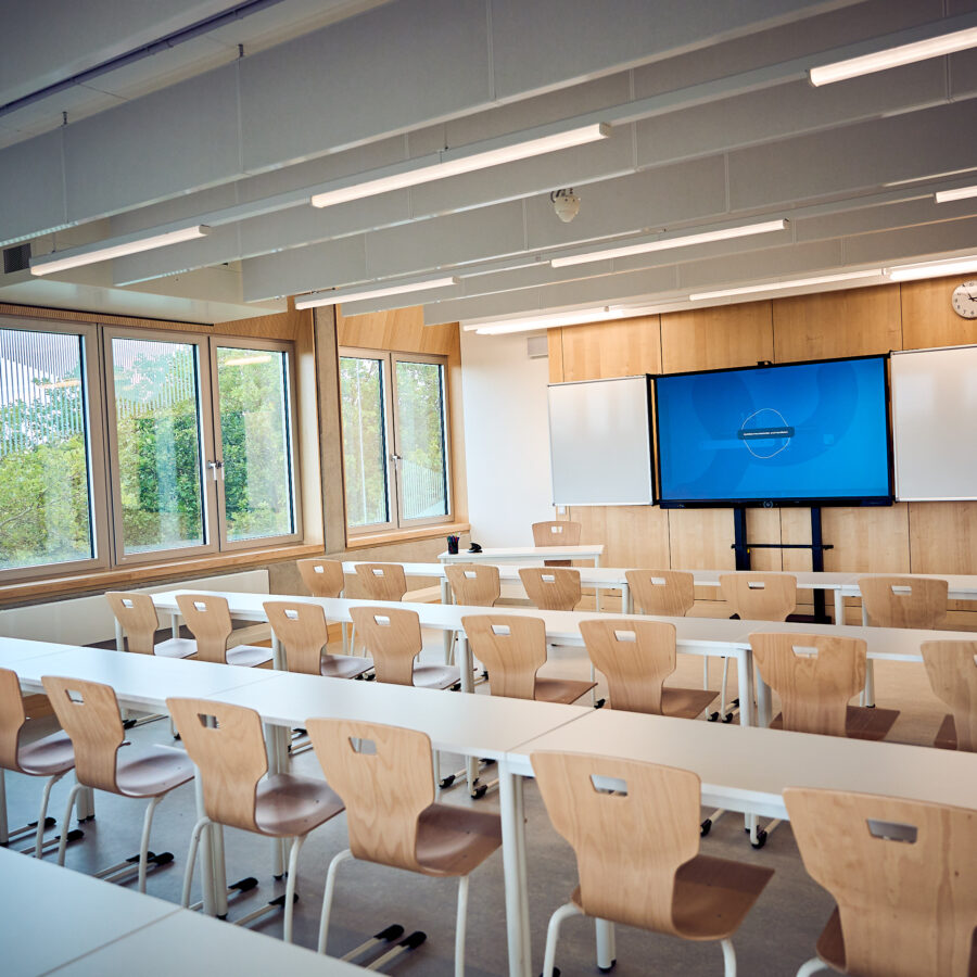 Moderne Klassenzimmer mit Tischen, Stühlen und Präsentationstechnik für effektives Lernen.