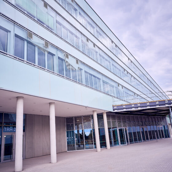 Modernes Gebäude mit Glasfassade und Eingangsbereich, ideal für Bildungseinrichtungen.