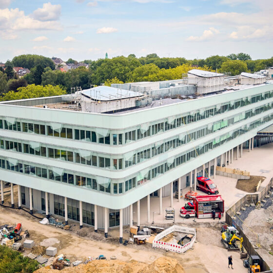 Ansicht des Schulzentrums Nord mit Baustelle in urbaner Umgebung.