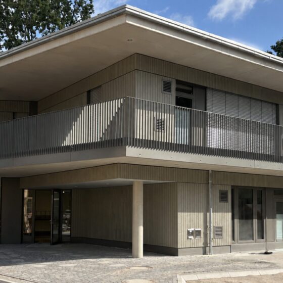 Moderne Architektur mit Holzverkleidung und großzügigem Balkon in einer ruhigen Umgebung.