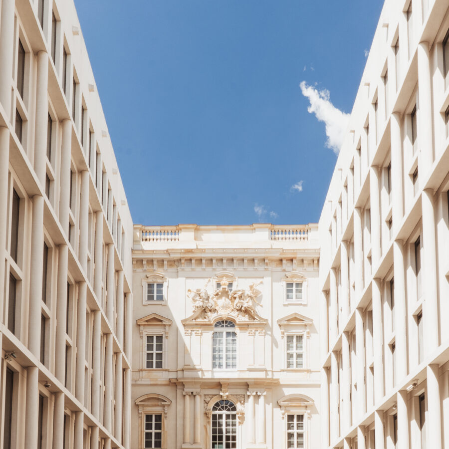 Historisches Gebäude zwischen modernen Architektur in einer urbanen Umgebung. Blauer Himmel.
