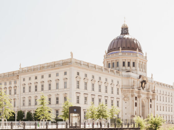 Historisches Gebäude mit Kuppel und schönen Pflanzen im Vordergrund, ideal für Architektur-Fans.