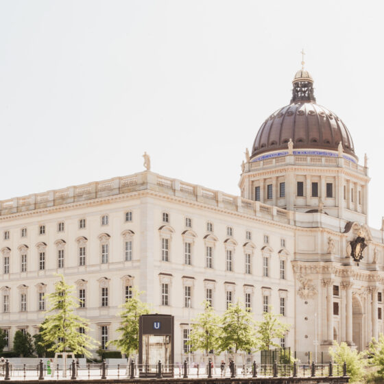 Historisches Gebäude mit Kuppel und schönen Pflanzen im Vordergrund, ideal für Architektur-Fans.