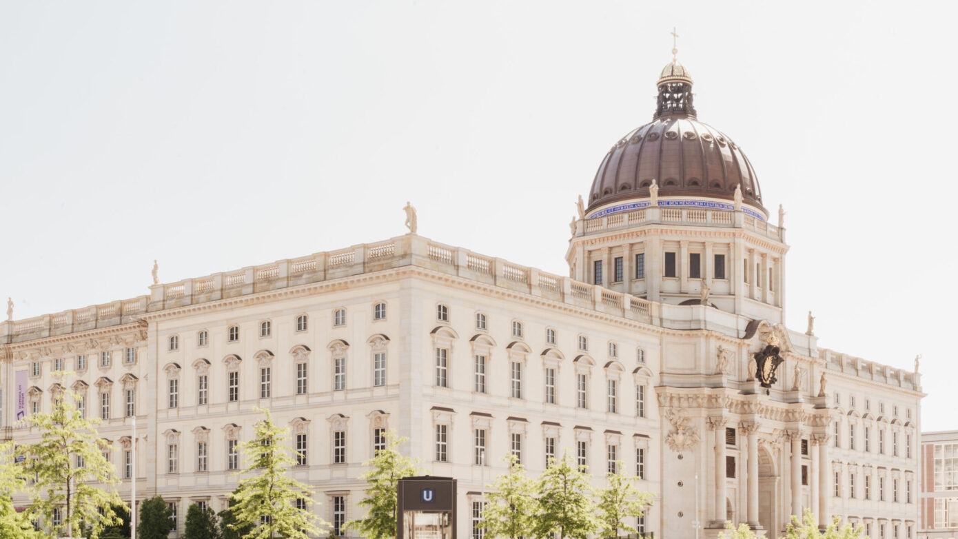Historisches Gebäude mit Kuppel und schönen Pflanzen im Vordergrund, ideal für Architektur-Fans.