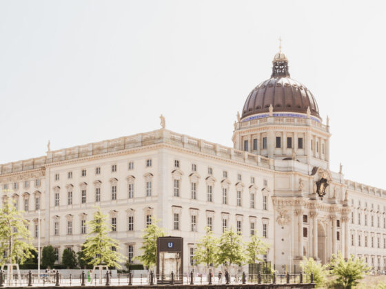 Historisches Gebäude mit Kuppel und schönen Pflanzen im Vordergrund, ideal für Architektur-Fans.
