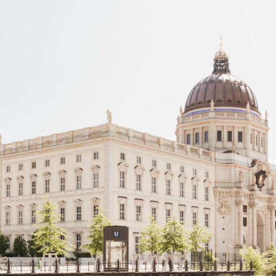 Historisches Gebäude mit Kuppel und schönen Pflanzen im Vordergrund, ideal für Architektur-Fans.