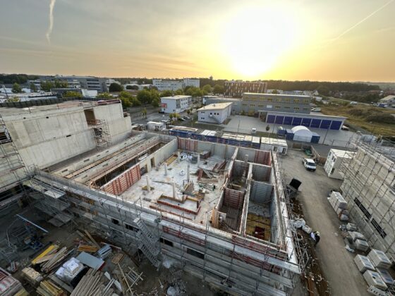 Bauprojekt mit Sonnenuntergang: Sicht auf Baustelle und umliegende Gebäude.