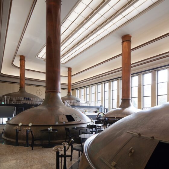 Sudpfannen (Kupferkessel) in einer Brauerei, große Fenster sorgen für Tageslicht.