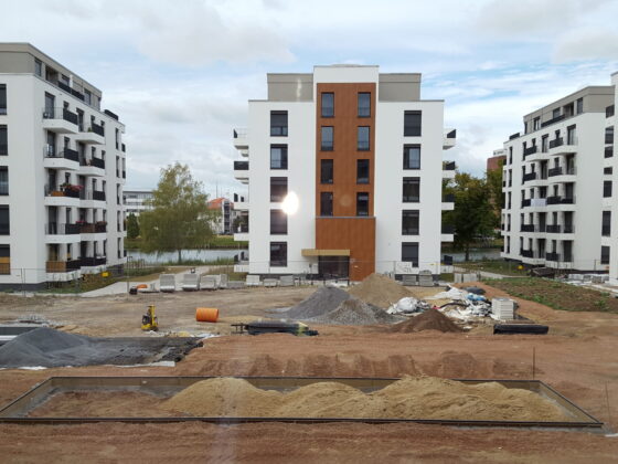 Bauprojekt mit modernen Wohngebäuden und Baustellenmaterialien in städtischer Umgebung.