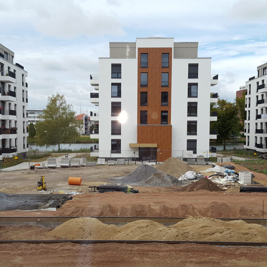 Bauprojekt mit modernen Wohngebäuden und Baustellenmaterialien in städtischer Umgebung.