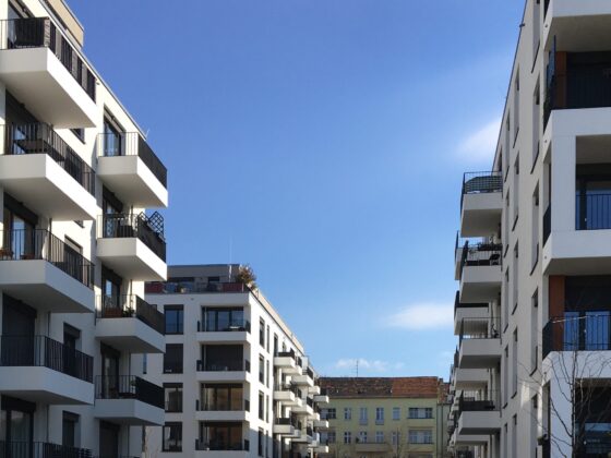 Moderne Wohngebäude mit Balkonen unter blauem Himmel in städtischer Umgebung.