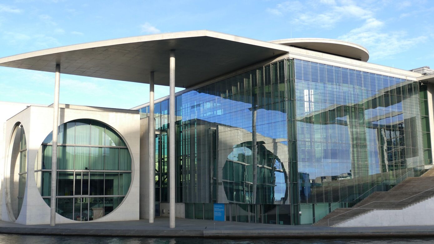 Moderne Architektur des Bundeskanzleramts in Berlin mit Glasfassade und Wasseransicht.