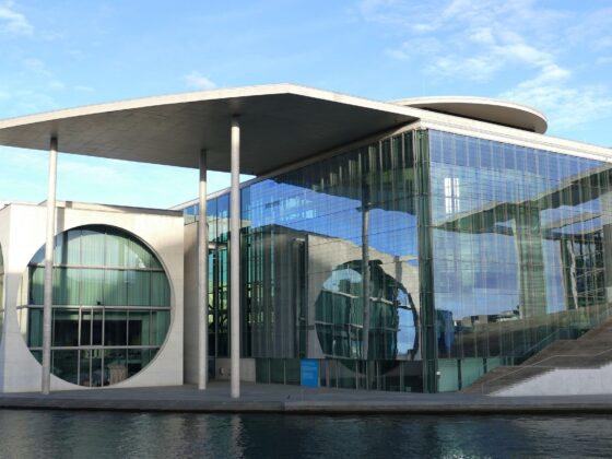 Moderne Architektur des Bundeskanzleramts in Berlin mit Glasfassade und Wasseransicht.