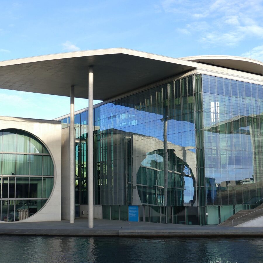 Moderne Architektur des Bundeskanzleramts in Berlin mit Glasfassade und Wasseransicht.