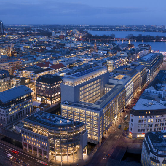 Luftaufnahme von Hamburg bei Nacht mit beleuchteten Gebäuden und Hafenansicht.