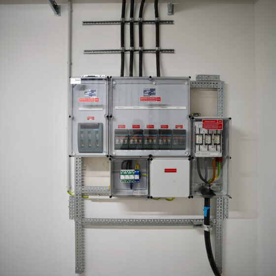Moderne Elektroinstallation mit Sicherungskästen und Kabelmanagement in einem Raum.