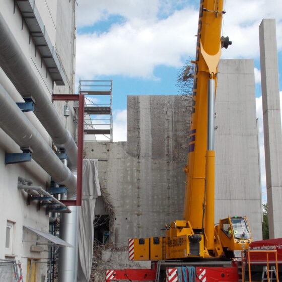 Bauarbeiten mit Kran und Maschinen an einem modernen Gebäude. Baustelle in Aktion.