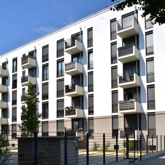 Moderne Wohnanlage mit Balkonen und grüner Umgebung in urbaner Lage.