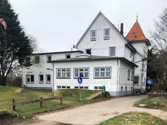 Haus des Gastes auf Amrum mit Garten und Gehweg, ideal für Spaziergänge und Erholung.