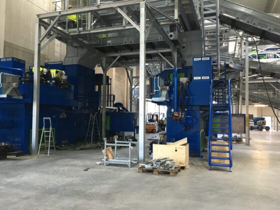 Moderne Maschinen in einer industriellen Produktionsumgebung mit Arbeitern und Ausrüstung.