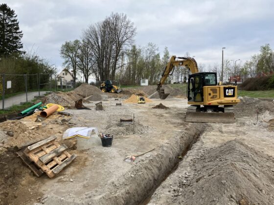 Bauplatz mit Bagger und Baumaschinen, Erdarbeiten in vollem Gange.