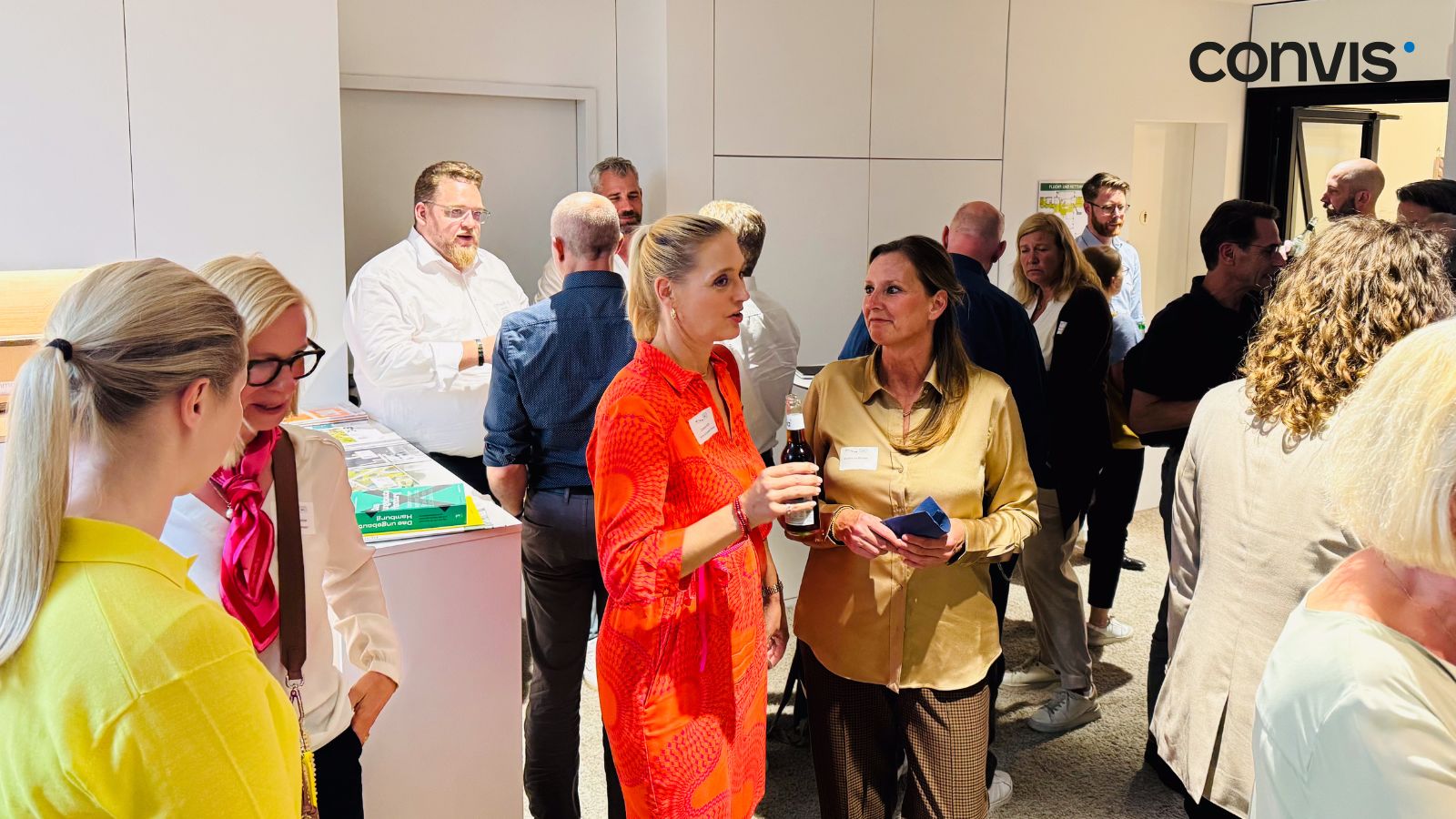 Networking-Event mit Teilnehmern in einem modernen Raum, Gespräche und Austausch im Vordergrund.