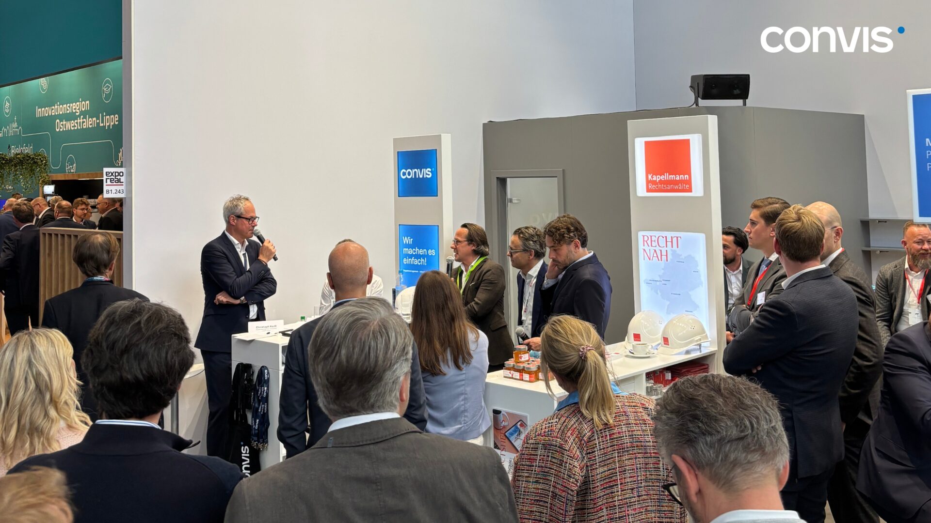 Messestand von Convis mit Präsentation und interessierten Besuchern auf einer Fachmesse.