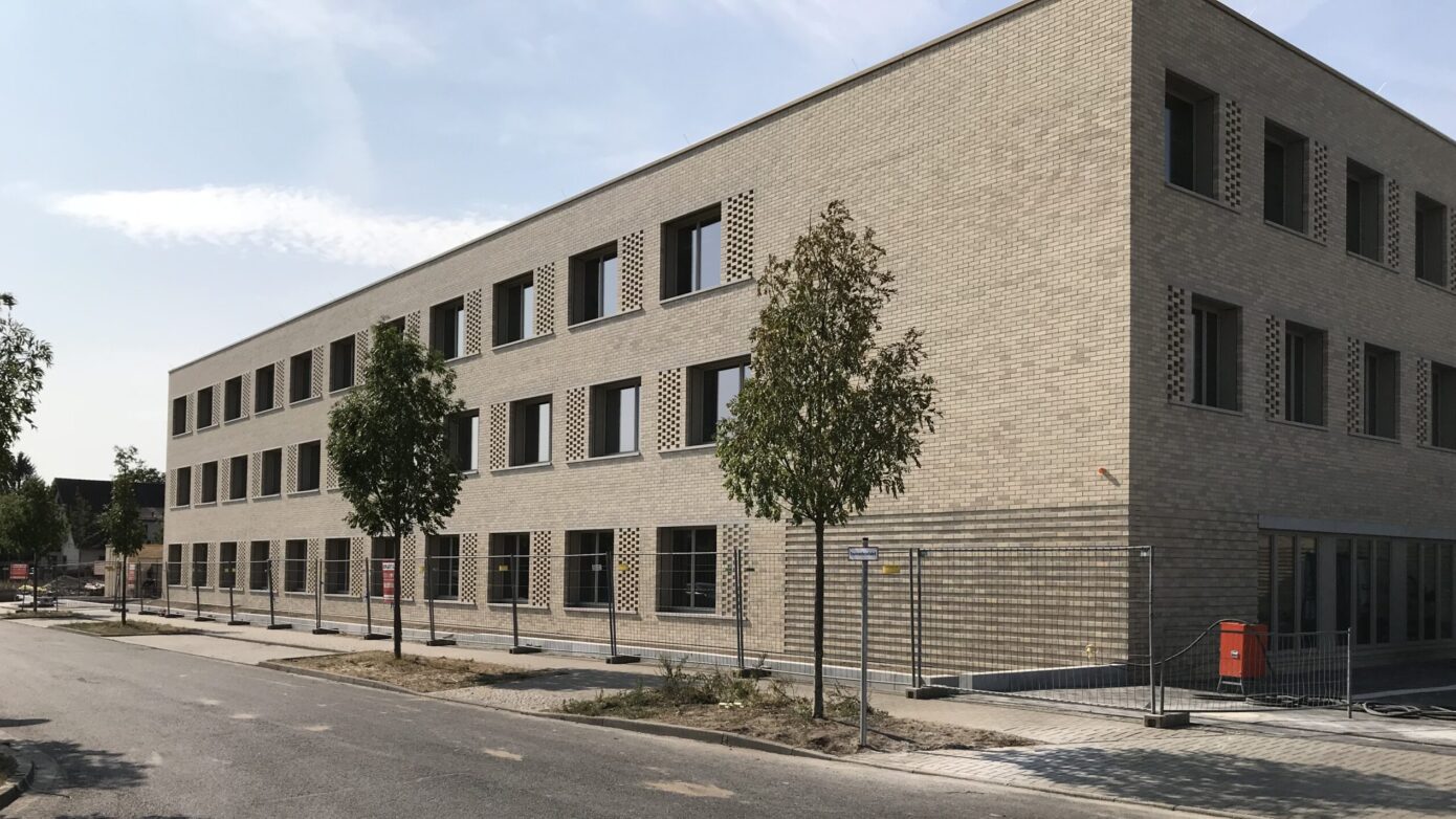 Fuchsberg-Grundschule mit moderner Gebäudefassade mit Fenstern und Bäumen in urbaner Umgebung.