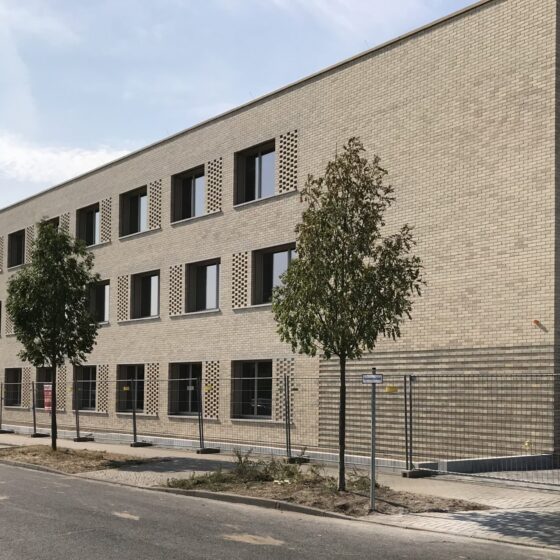 Fuchsberg-Grundschule mit moderner Gebäudefassade mit Fenstern und Bäumen in urbaner Umgebung.