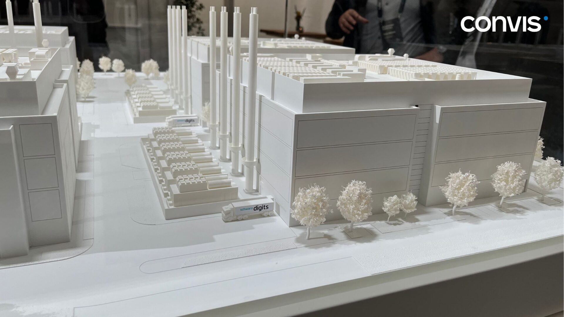 Modell eines modernen Industriekomplexes mit weißen Gebäuden und Bäumen.