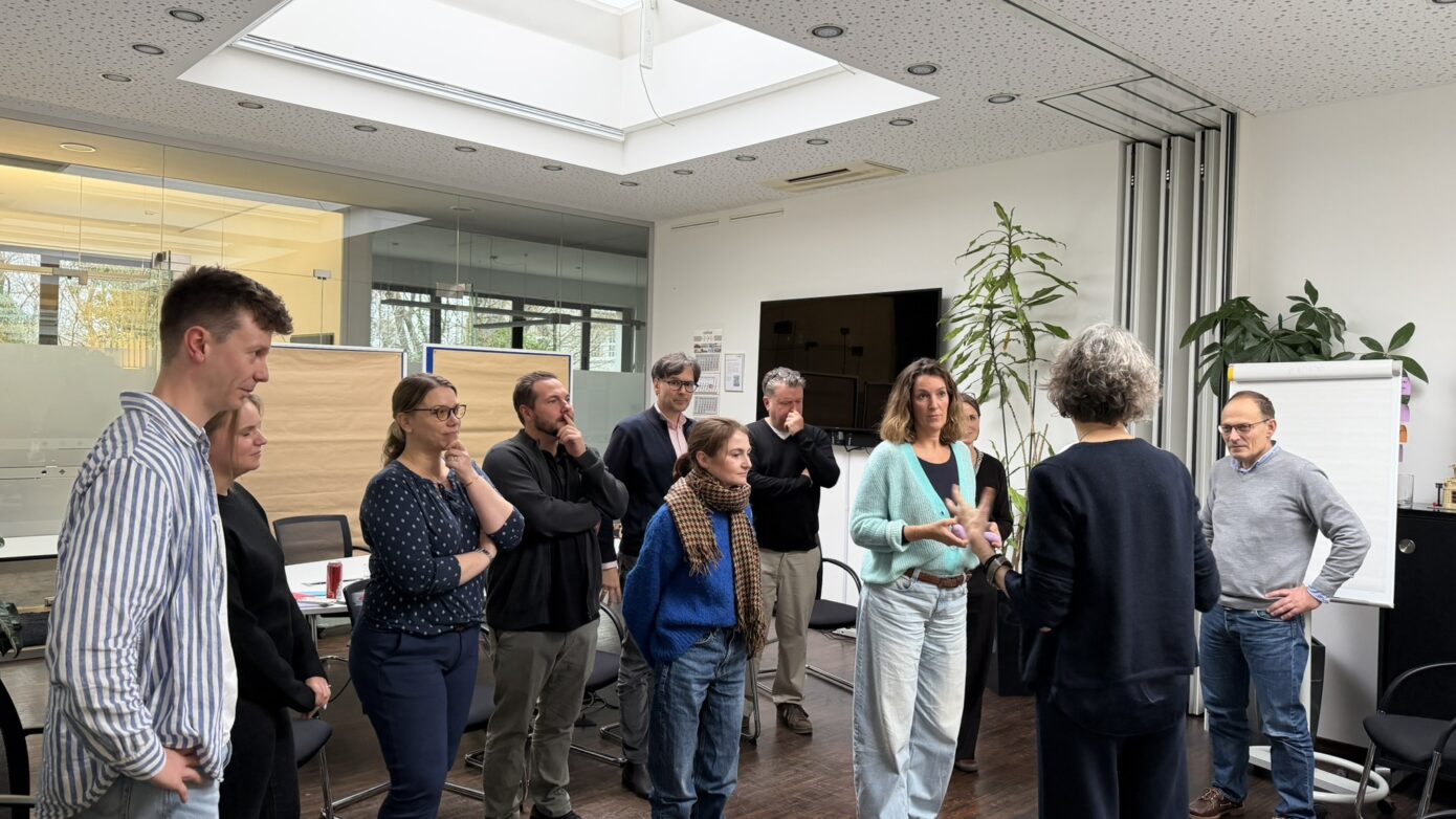 Gruppendiskussion in modernem Büro mit Menschen, die aktiv miteinander kommunizieren.
