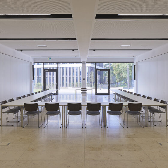 IHK-Nord Westphalen Münster von innen mit moderner Konferenzraumgestaltung mit Tisch und Stühlen, viel Tageslicht und minimalistischer Ästhetik.