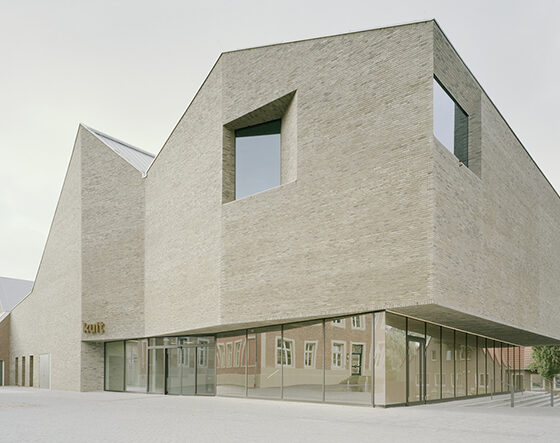 Moderne Architektur: Innovative Backsteinfassade eines zeitgenössischen Gebäudes in städtischer Umgebung.