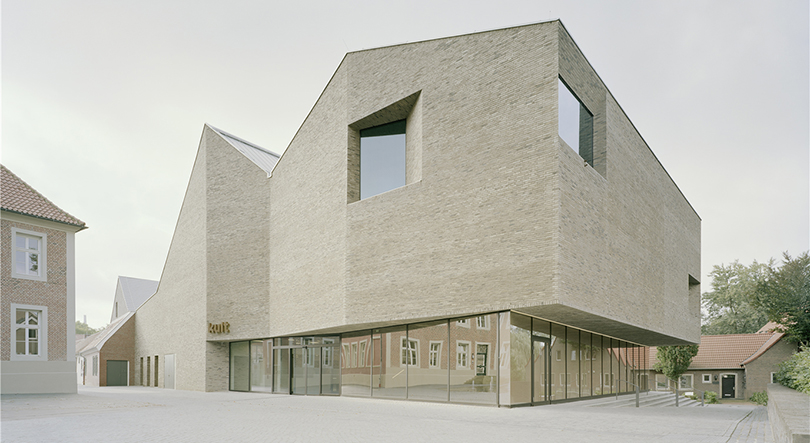 Moderne Architektur: Innovative Backsteinfassade eines zeitgenössischen Gebäudes in städtischer Umgebung.